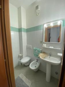 ein Badezimmer mit einem Waschbecken, einem WC und einem Spiegel in der Unterkunft Raggi di Sole in Monterosso al Mare