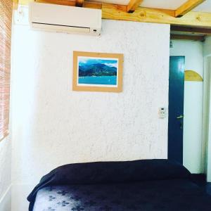 - une chambre avec un lit et une photo sur le mur dans l'établissement Hostel Otro Mundo, à Mendoza