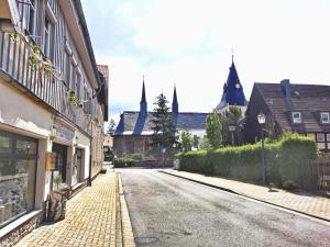 eine leere Straße in einer Stadt mit Häusern und Kirchen in der Unterkunft Altstadt Pension Orchidee in Wernigerode