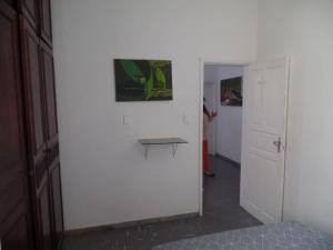 a room with a white wall with a picture on the wall at Wally's House Hostel in Belo Horizonte