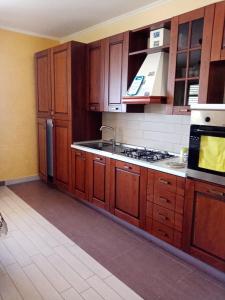 kuchnia z drewnianymi szafkami i piekarnikiem w obiekcie Appartamento Mariella via Lipari n 8 w mieście Pachino +7 zdjęć