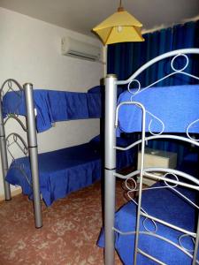 - une chambre avec des lits superposés et des draps bleus dans l'établissement Hostel Otro Mundo, à Mendoza