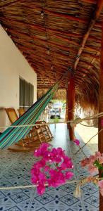 a hammock in a room with flowers on the floor at Cabañas La Cuchita RNT 61621 in Coveñas
