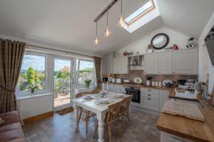 a kitchen with a table and a clock on the wall at Harper’s Cottage, Fence, Lancashire in Brierfield