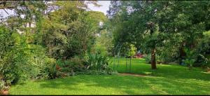 a garden with green grass and trees and a gate at Twiga Hill Gardens in Nairobi