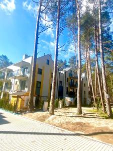 a building with trees in front of it at Apartament LEA in Międzywodzie