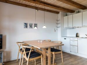 - une cuisine avec une table et des chaises en bois dans l'établissement Holiday home Henne XXXVIII, à Henne Strand