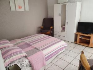 a small bedroom with a bed and a tv at Meublés B-D in Bains-les-Bains
