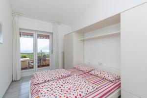 Biała sypialnia z 2 łóżkami i balkonem w obiekcie Apartament Kormorano w mieście Malcesine +21 zdjęć