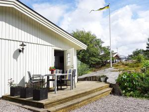 een houten terras met een tafel en stoelen op een huis bij 2 person holiday home in STR MSTAD in Strömstad