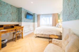 um quarto de hotel com uma cama e uma secretária em Grand Hotel Normandy by CW Hotel Collection em Bruges