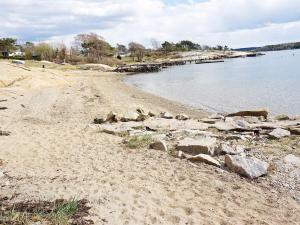 a sandy beach with rocks and the water at 2 person holiday home in STR MSTAD in Strömstad