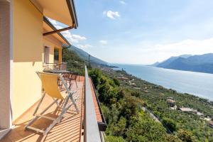 a balcony with a chair and a view of the water at Casa Prea Apartments in Malcesine