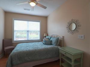 Schlafzimmer mit einem Bett, einem Deckenventilator und einem Fenster in der Unterkunft Havens 712 Condo in Myrtle Beach