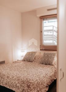 a bedroom with a bed and a window at Le Ponton C.L.S Deauville in Deauville