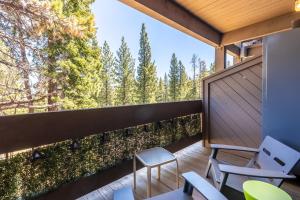 a balcony with chairs and a view of the woods at Modern Hotel-Style Studio - Timber Creek Lodge #210 Hotel Room in Truckee
