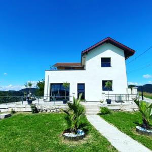 una casa blanca con palmeras delante en Villa Bellevue "Rez-de-chaussée", en Belley