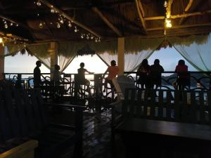 a group of people sitting at a table in a restaurant at Hotel Aurora in Flores