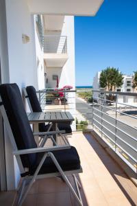 uma varanda com duas cadeiras e uma mesa num edifício em Nortada Suite Beach Apartment T2 em Lagos