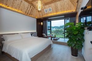 张家界Heaven's Gate Home Stay --free pick up service--panoramic view of Tianmen Mountain的卧室里有一张白色的床和一扇大窗户
