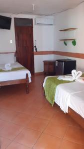 Zimmer mit 2 Betten und TV in der Unterkunft Cabinas coco azul Guanacaste in Guanacaste