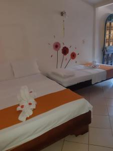 2 Betten in einem Zimmer mit Blumen darauf in der Unterkunft Cabinas coco azul Guanacaste in Guanacaste