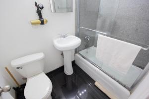 um banheiro com vaso sanitário, pia e chuveiro em Studio Plus - Cozy Apartments em Nova Iorque