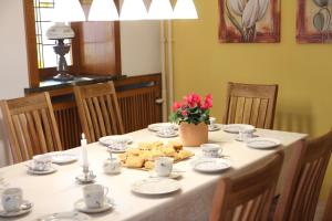 a table with plates and cups and flowers on it at Landhaus Büttner Altenberg, zentral, familienfreundlich, Skihang & Erlebnisberg fußläufig in Kurort Altenberg