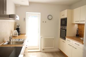 a kitchen with a sink and a clock on the wall at Landhaus Büttner Altenberg, zentral, familienfreundlich, Skihang & Erlebnisberg fußläufig in Kurort Altenberg +38 photos
