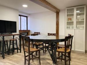 Zuzones的住宿－La Casa de la Abuela，一间带桌椅和电视的用餐室