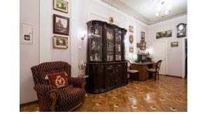 a living room with a china cabinet and a chair at View on Neva in Saint Petersburg