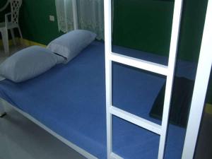 a bunk bed with a blue mattress next to a ladder at RAVARA NATIVIDAD PENSION HOUSE in Alaminos