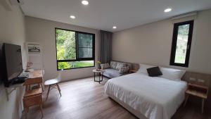 1 dormitorio con 1 cama, escritorio y 2 ventanas en 印象莊園包棟民宿,一日一組客人,依人數開房, en Xihu