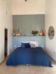 1 dormitorio con cama azul y manta azul en Chez Brunet chambres d'hôtes et gîte, en Gondrin