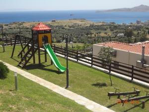 een speeltuin met een glijbaan en een glijbaan bij Aegea Hotel in Karistos