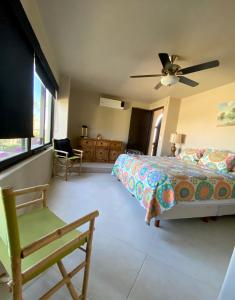 ein Schlafzimmer mit einem Bett, einem Fernseher und einem Stuhl in der Unterkunft Spectacular Vacation Home Ocean View Walk to Beach in Cabo San Lucas
