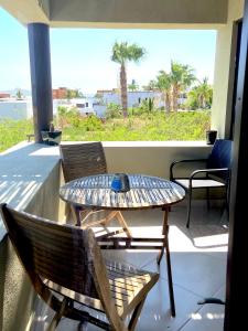 ein Tisch und Stühle auf einem Balkon mit Blick auf das Meer in der Unterkunft Spectacular Vacation Home Ocean View Walk to Beach in Cabo San Lucas