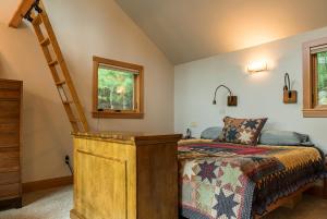 a bedroom with a bed and a ladder next to a window at Private Home Overlooking Stevens Lake in Great Barrington