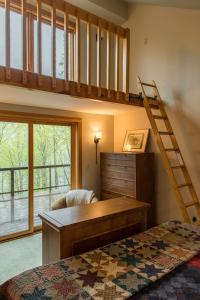 1 dormitorio con cama elevada y escritorio en Private Home Overlooking Stevens Lake, en Great Barrington