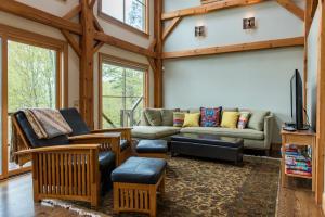 a living room with a couch and a tv at Private Home Overlooking Stevens Lake in Great Barrington