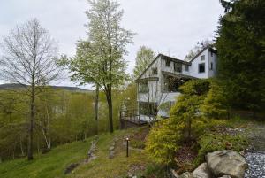 a house on top of a hill in the woods at Private Home Overlooking Stevens Lake in Great Barrington