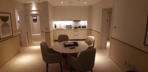 a room with a table and chairs and a kitchen at Apartment at Address in El Alamein