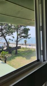 a window in a room with a view of a beach at Ureki House in Ureki