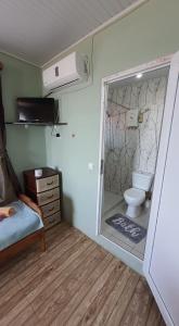 łazienka z toaletą, łóżkiem i oknem w obiekcie Ureki House w mieście Ureki