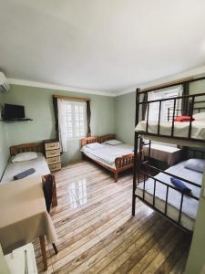 Pokój z 3 łóżkami piętrowymi i telewizorem w obiekcie Ureki House w mieście Ureki