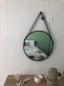a mirror hanging on a wall next to a bed at Akrogiali House in Skala Kallirakhis