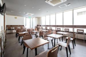 a classroom with tables and chairs and a whiteboard at Cabin & Capsule Hotel J-SHIP Osaka Namba in Osaka