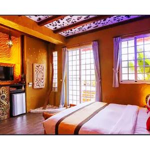 墾丁的住宿－墾丁巴里巴里，一间卧室设有一张床和两个窗户。