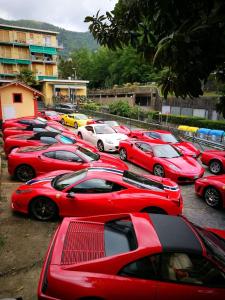 a row of red cars parked in a parking lot at Hotel Canali - Le Cinque Terre in Rapallo