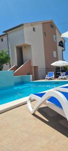 a swimming pool in front of a building at Apartments Villa Natali - Heating Pool in Trogir